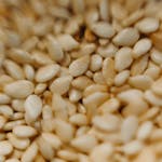 Detailed macro photography of raw sesame seeds capturing texture and earthy tones.